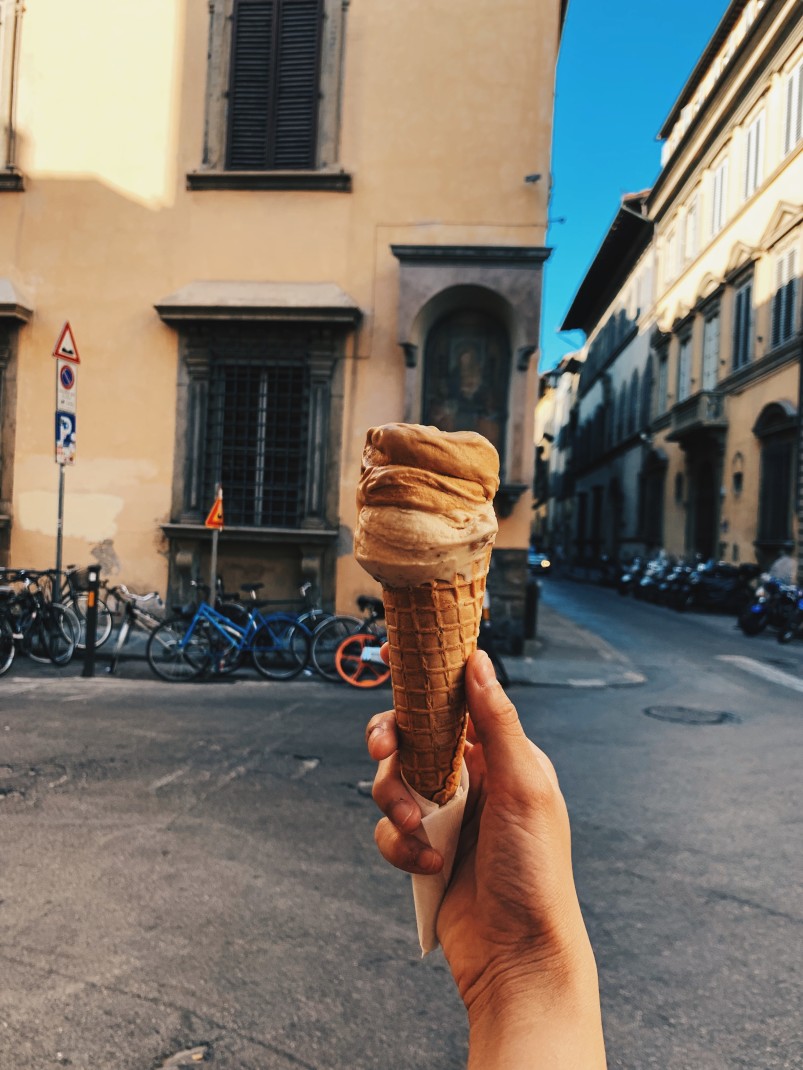 person holding an ice cream cone during daytime