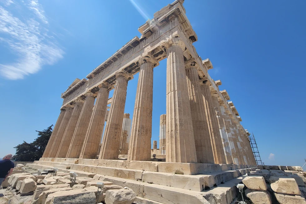 An old building with concrete pillars in daytime.
