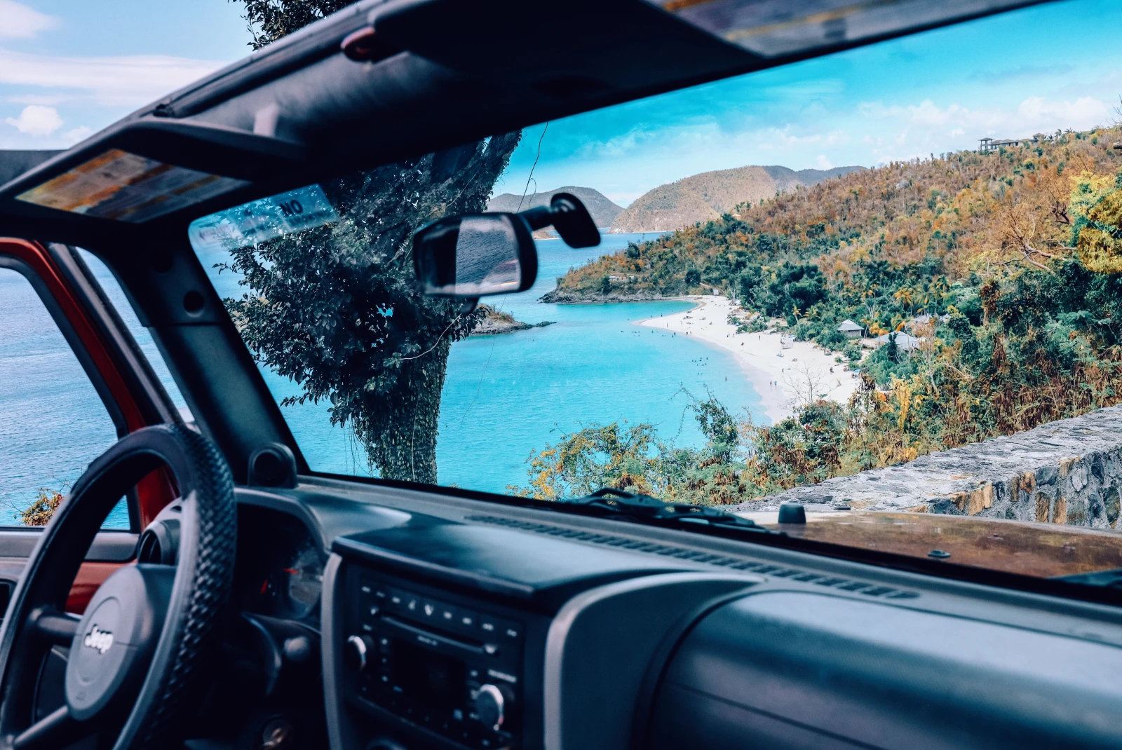 View of blue waters and the beach in St. John out the window of a black jeep