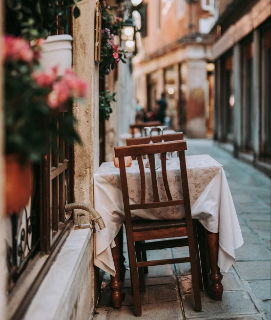 table with white tablecloth in alleyway during daytime
