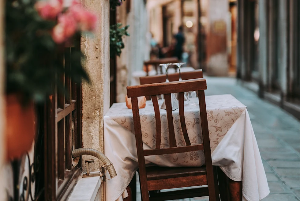 table with white tablecloth in alleyway during daytime