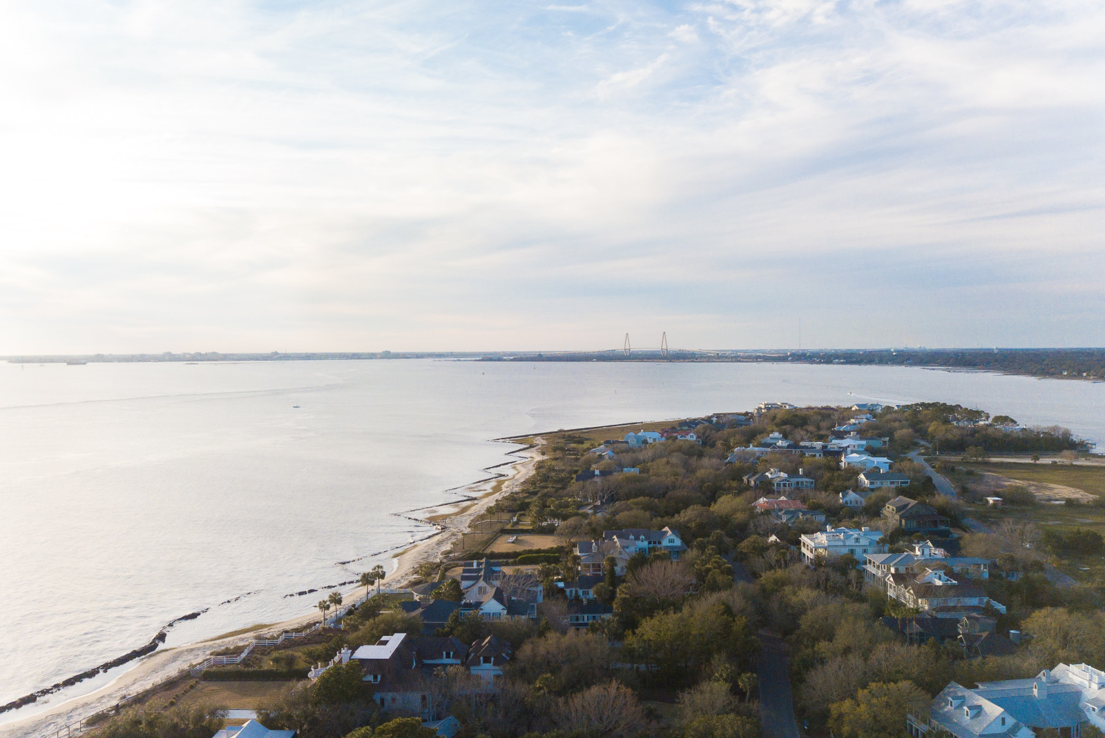 Aerial view of land with houses next to body of water during daytime