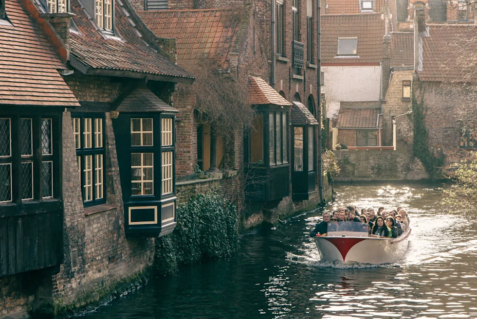 Boat packed with tourists passing houses