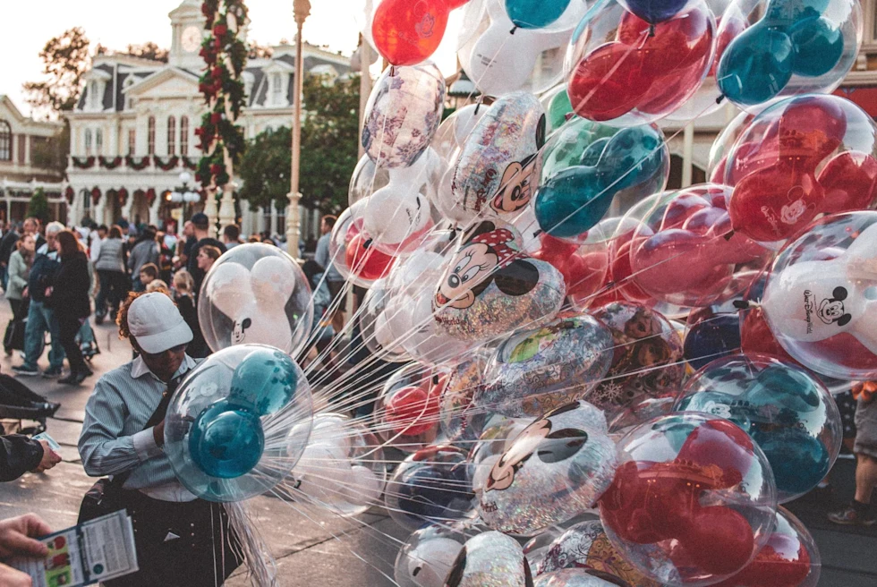 man with a bunch of colorful balloons