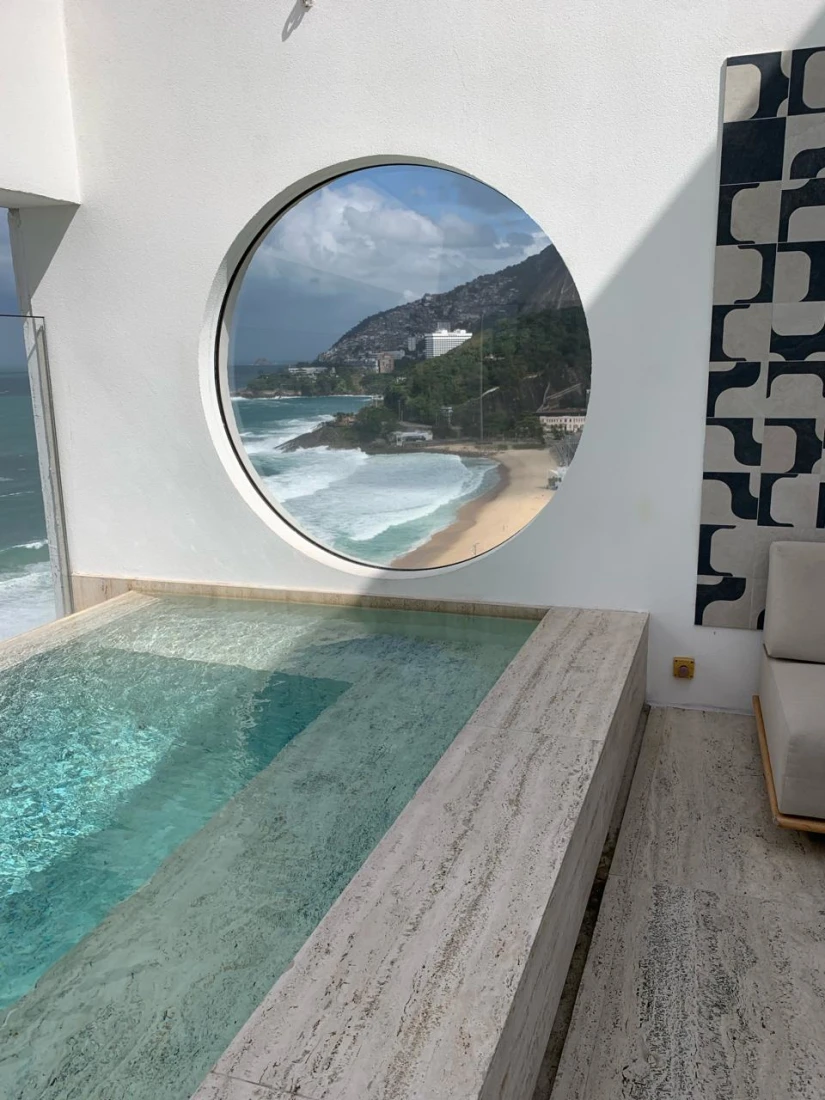 Interior pool with circular window looking out to the beach
