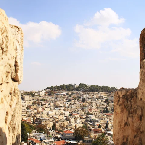 stone wall with buildings in the background during daytime