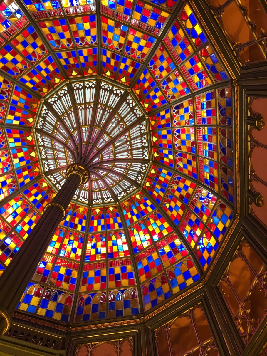 A bottom up view of a beautiful, multi-colored glass ceiling. 