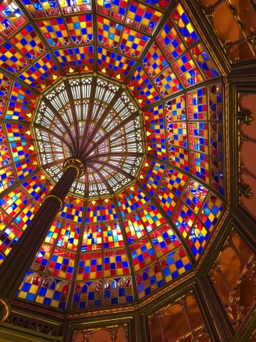 A bottom up view of a beautiful, multi-colored glass ceiling. 