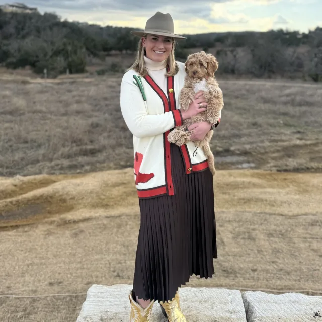 Barrett smiling and posing with her adorable dog in a western setting. 