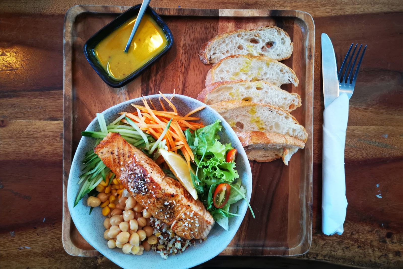 plate of salmon and veggies on brown table