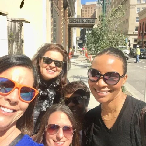 A selfie photo of a group of people outside in a city street