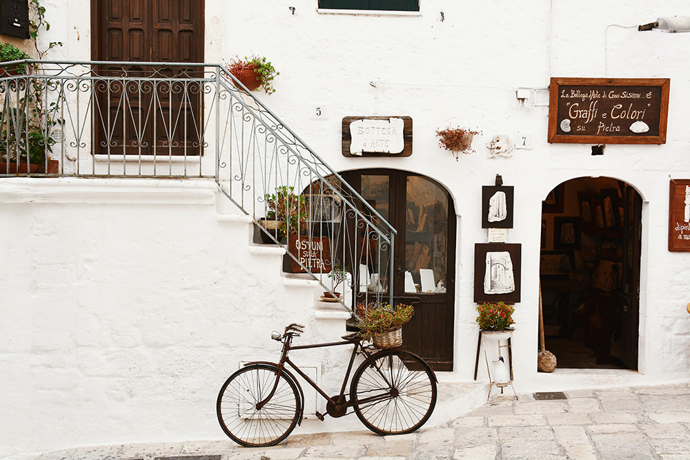 Bike ride through the whitewashed-building lined narrow streets of Puglia Italy.