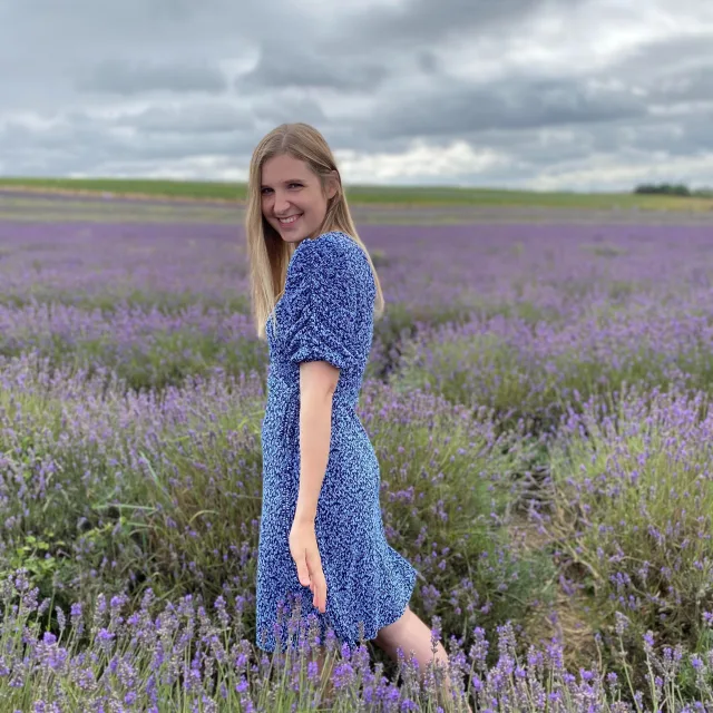Gabija in a blue dress, in the middle of a lavender field.