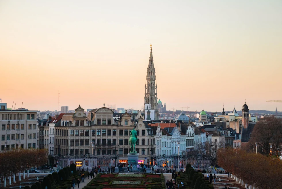 cityscape at sundown with tall church steeple rising high above the city