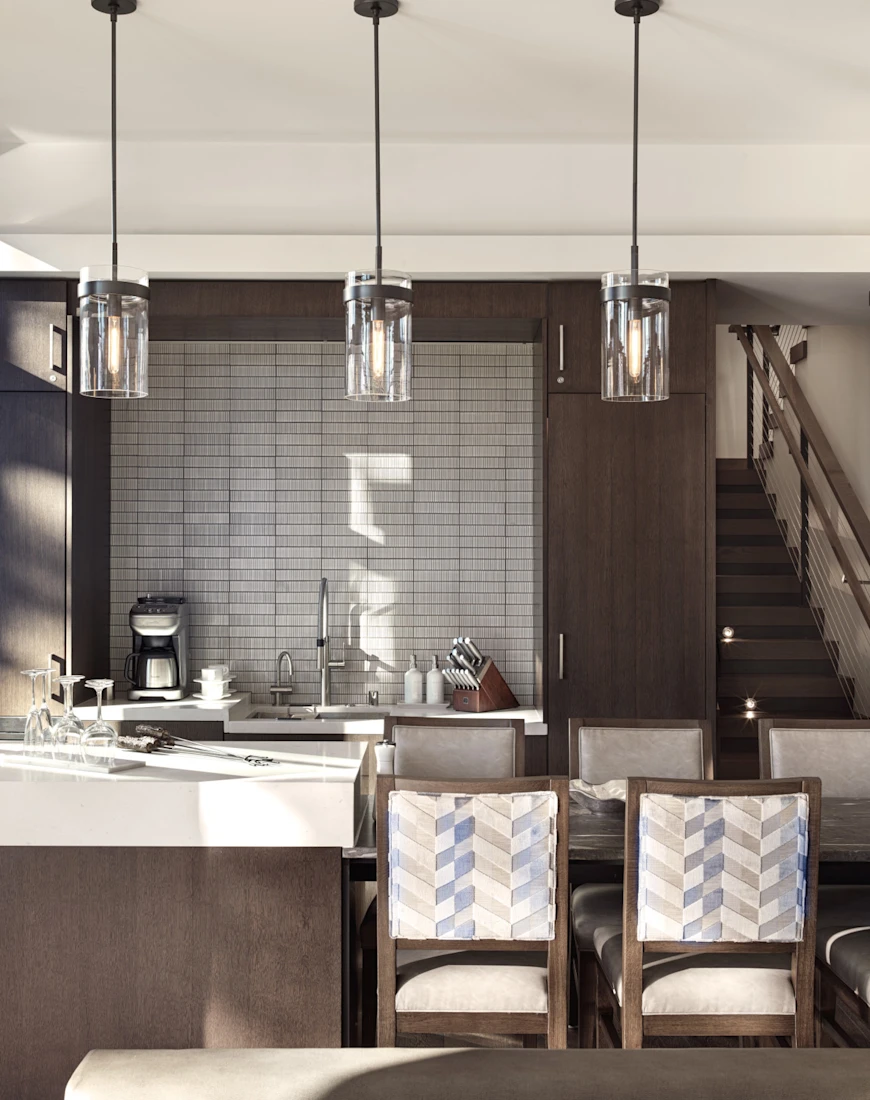 a modern kitchen with hanging glass lights