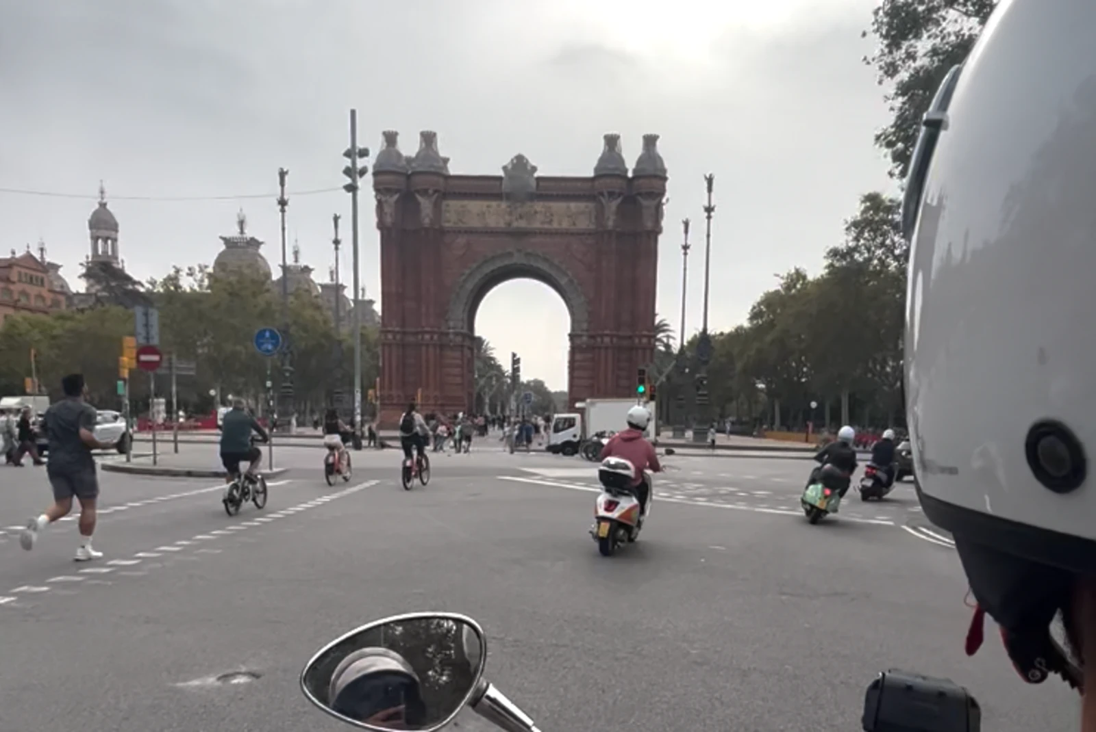 on a moped in front of an arch over the road
