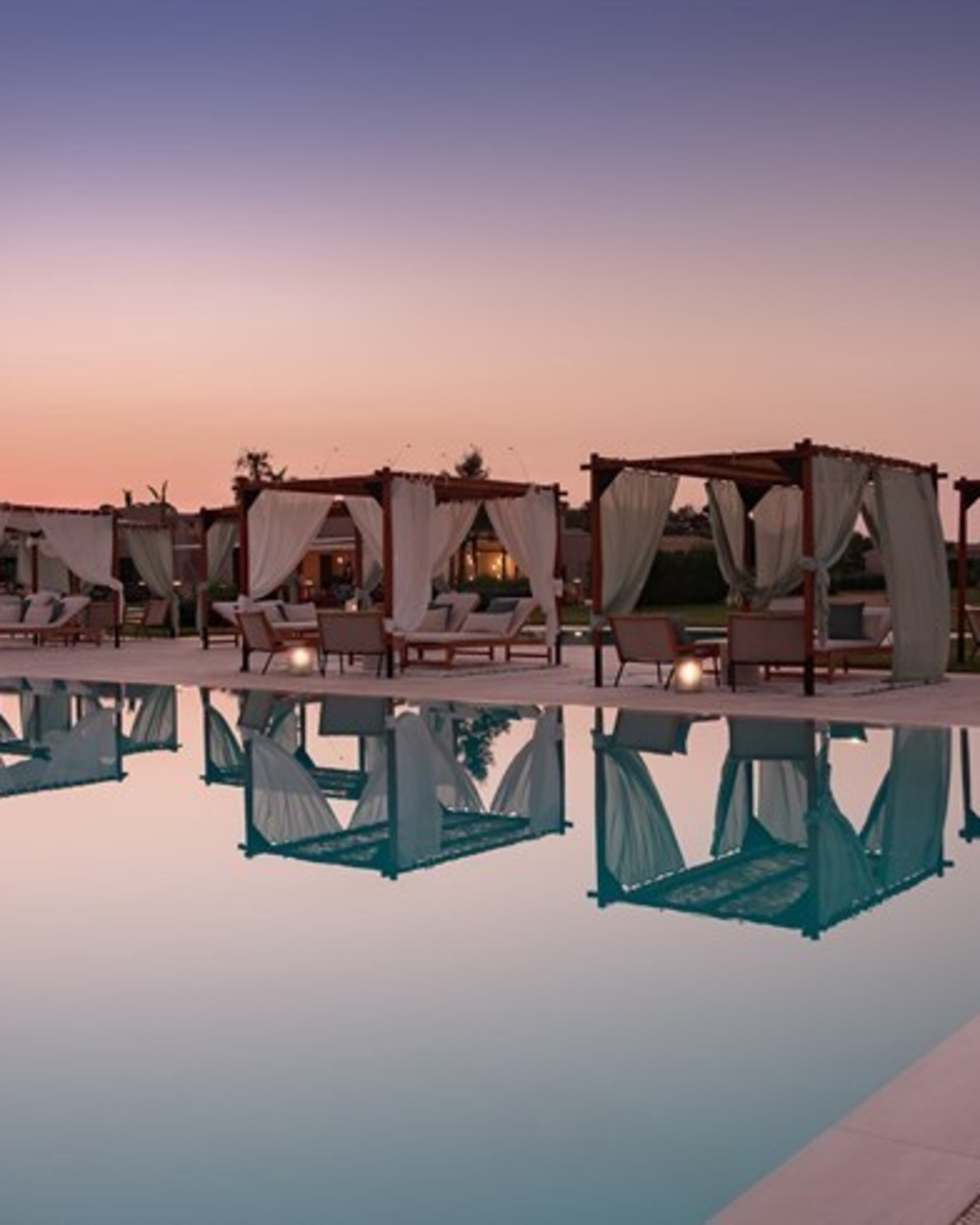 Cabana-bedecked infinity pool at sunset