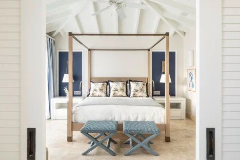four-post bed with blue stools at its base