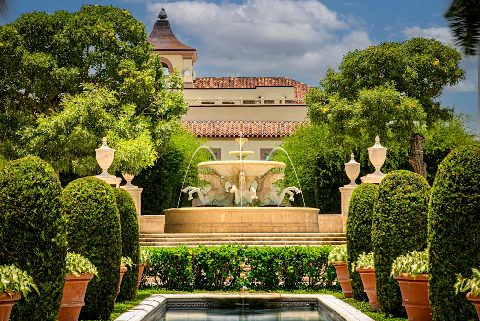 fountain surrounded by landscaping with cloudy skies during daytime