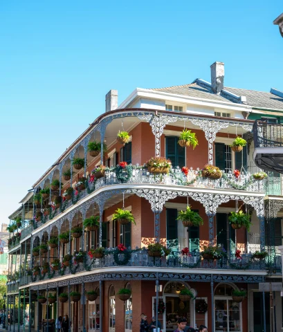 A corner view of a New Orleans apartment building with balconies decorated with flowers.