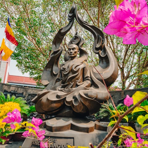 Statue of a Buddha surrounded by foliage.  