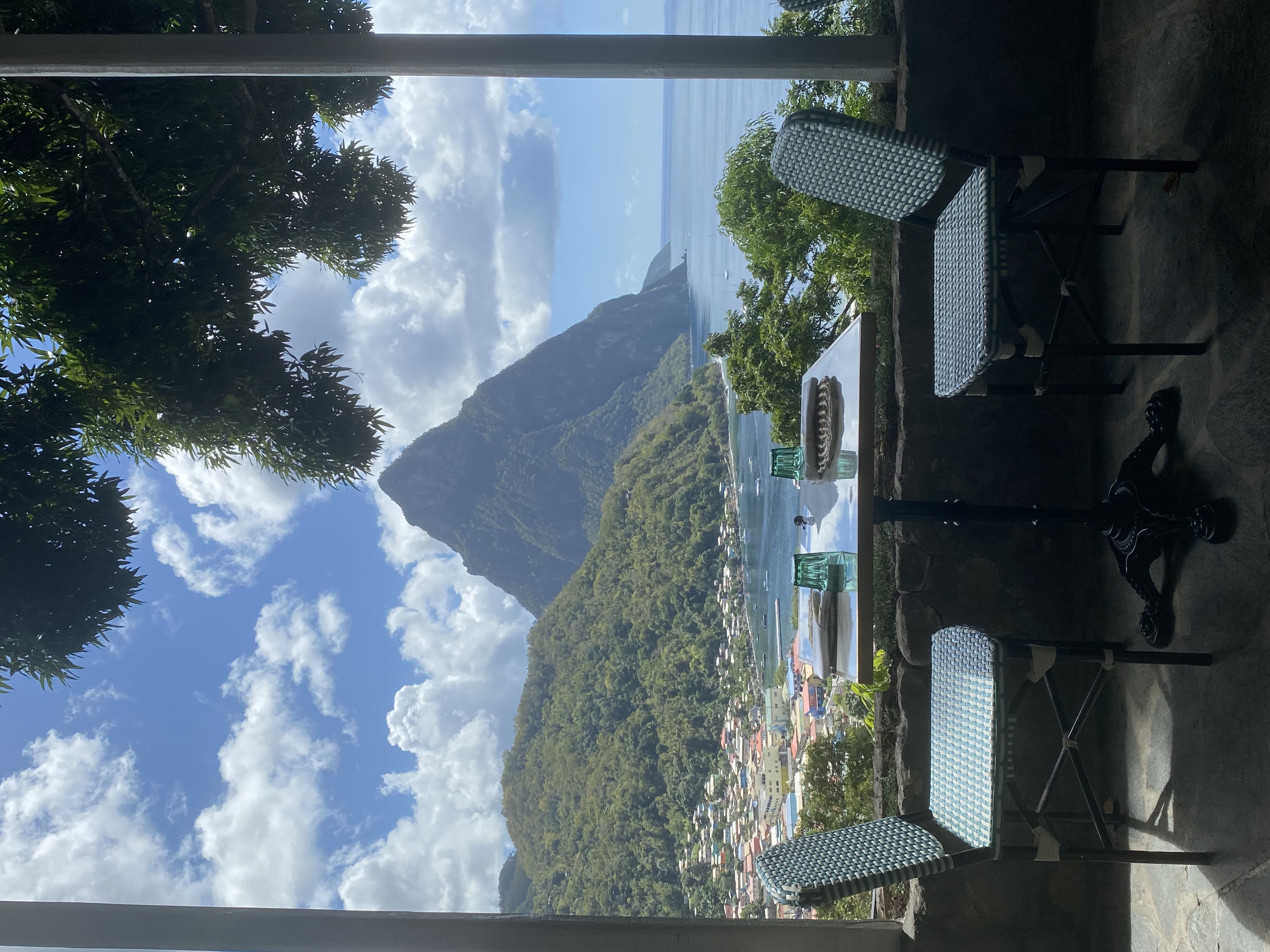 A table set for two in front of a forest, mountain and ocean view