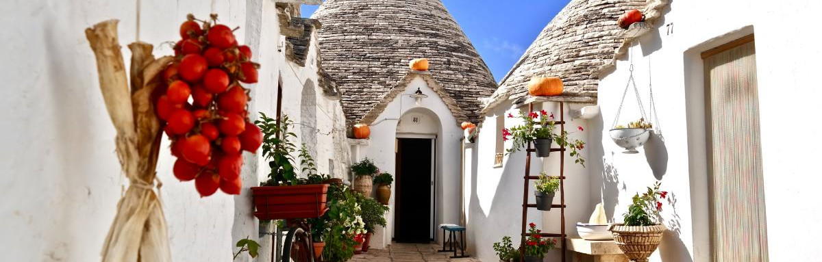 White buildings, cobblestone streets and narrow walkway in Puglia, Italy.