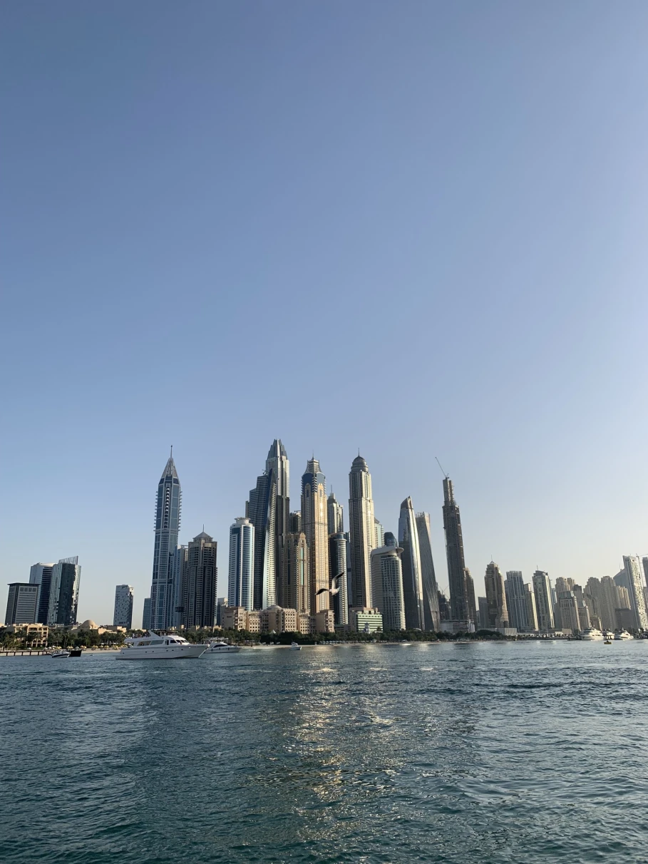 cityscape of a modern city from the ocean with cloudless blue sky