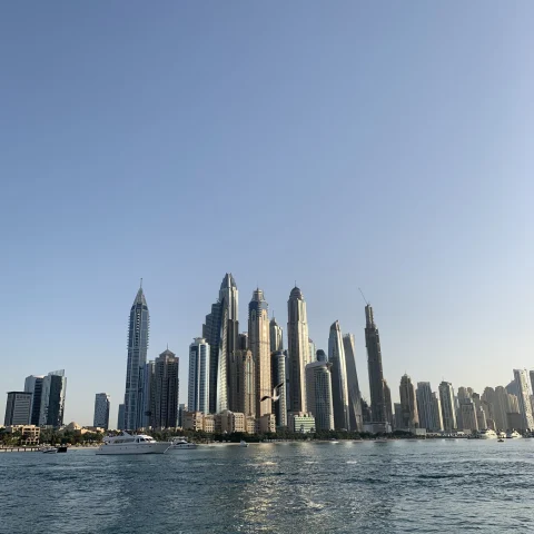 cityscape of a modern city from the ocean with cloudless blue sky