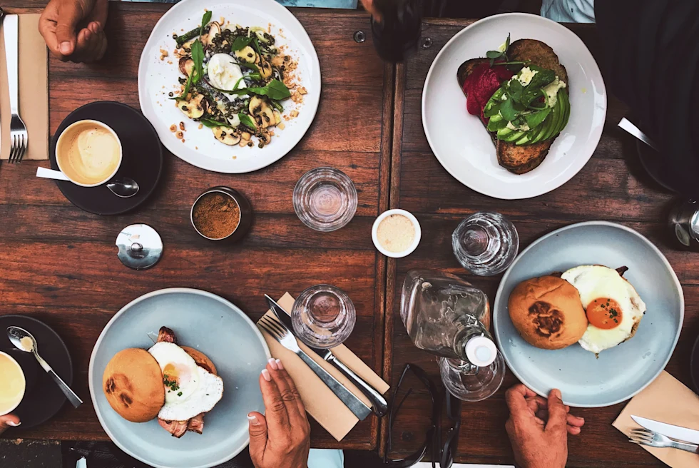A table with food and people eating.