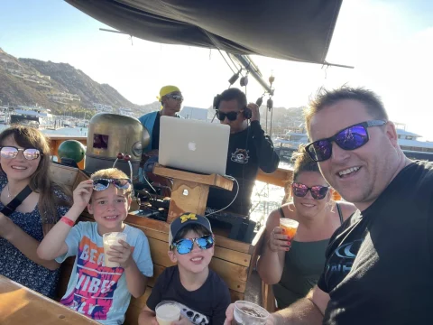 A family posing for a selfie photo on a boat during the daytime