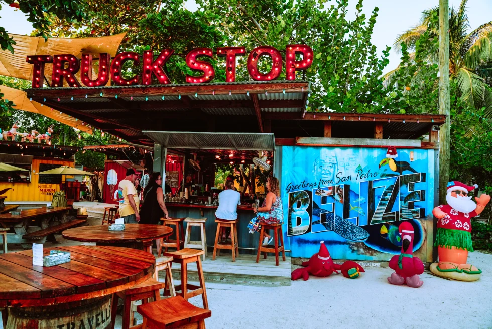 An outdoor cafe at belize, with people sitting on a brown chair.