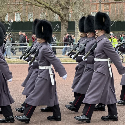 Changing of the Guard at Buckingham Palace in London with the guards dressed in traditional outfits and hats