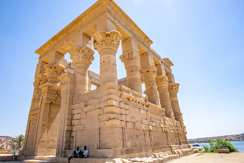 Two people sitting outside ancient building during daytime