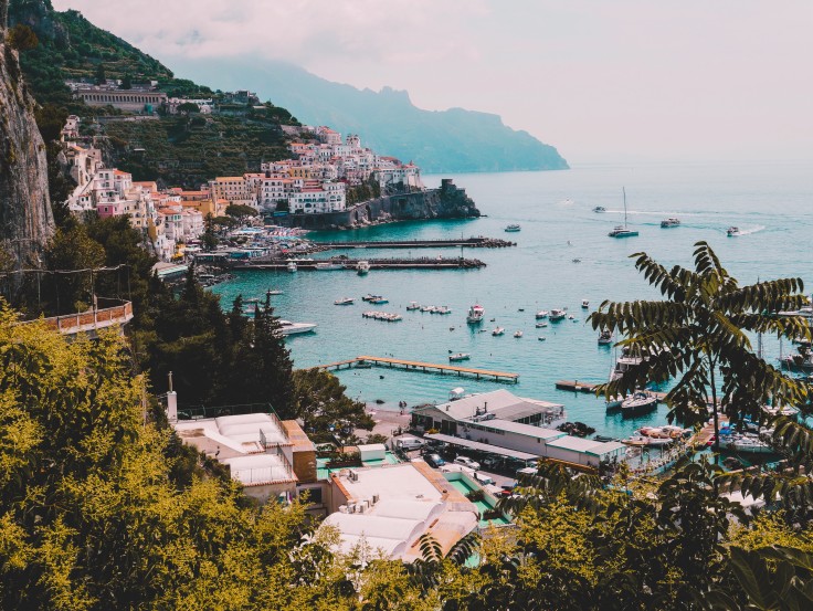 View of blue waters and coastline dotted with colorful buildings in Italy's Amalfi Coast