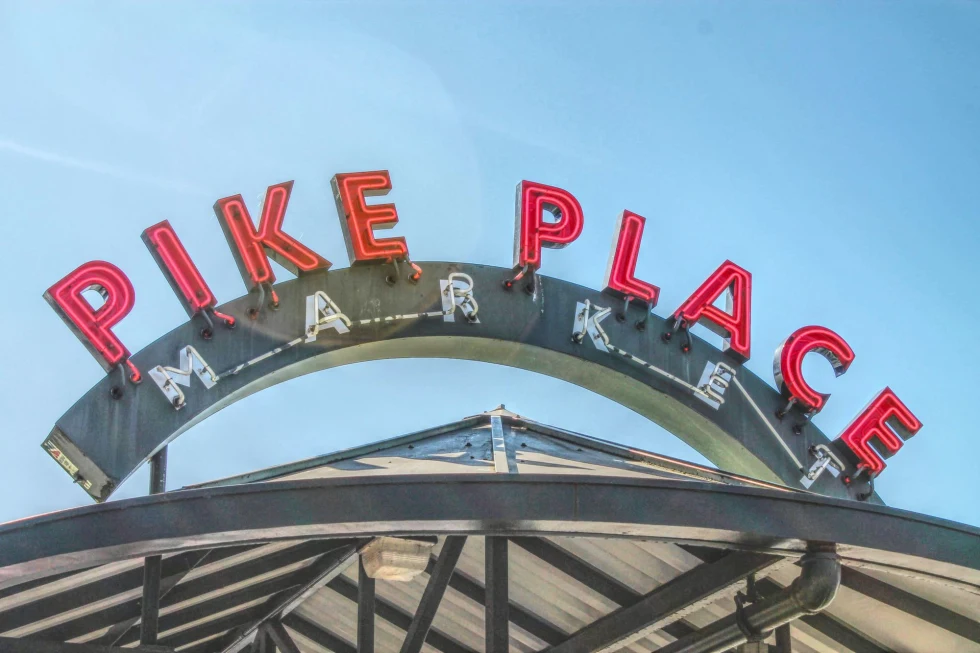 neon sign in red letters reads, "pike place market"