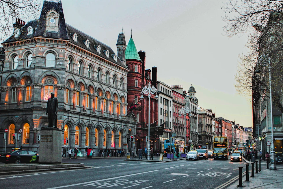 Buildings next to a street with cars during sunset