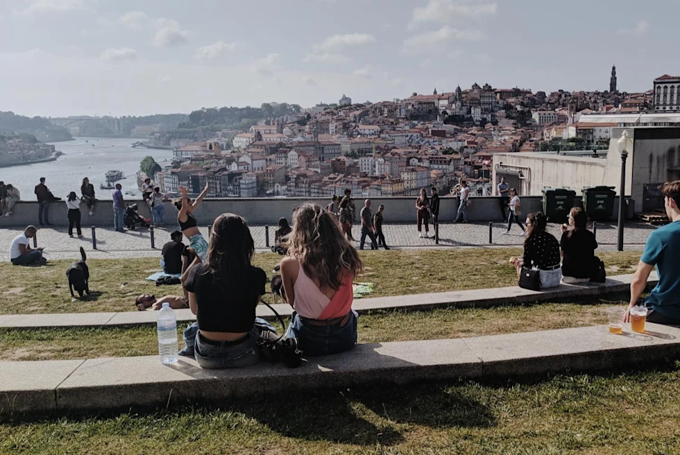 a busy park with people enjoying the view of a city below