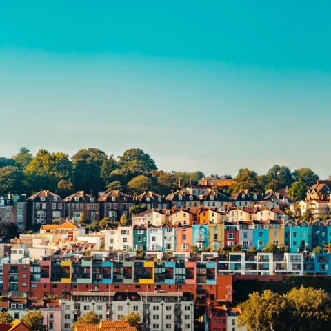 multi-colored houses on a hill with blue sky