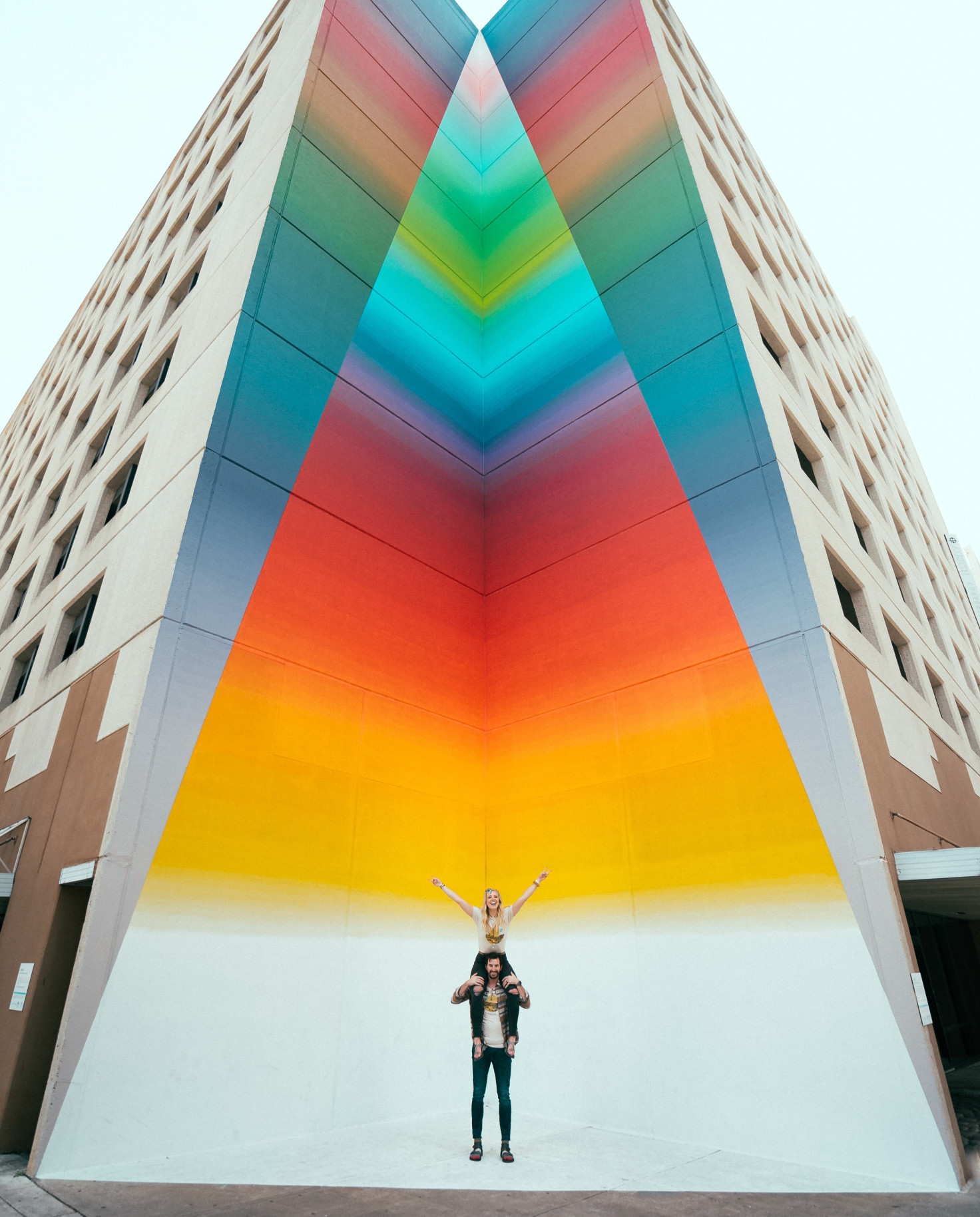 Couple standing in front of street art in Texas. 