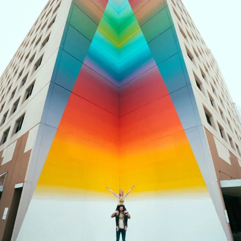 Couple standing in front of street art in Texas. 