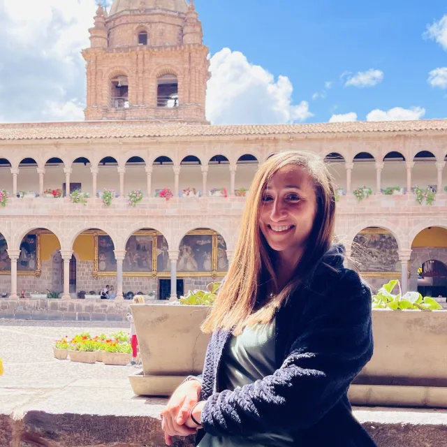 Travel advisor Ashley Reese posing with a smile in front of a historic building.