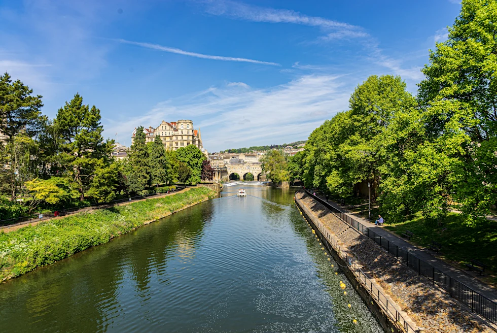 body of water with buildings in the distance with sunny skies
