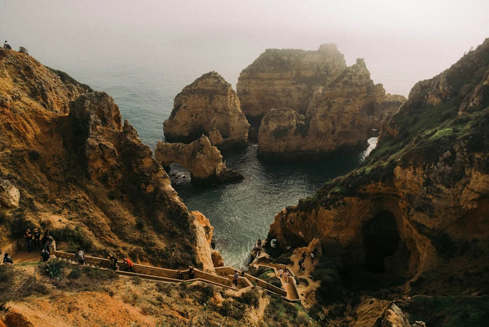 cliff walk above ocean with smaller cliffs rising from the water