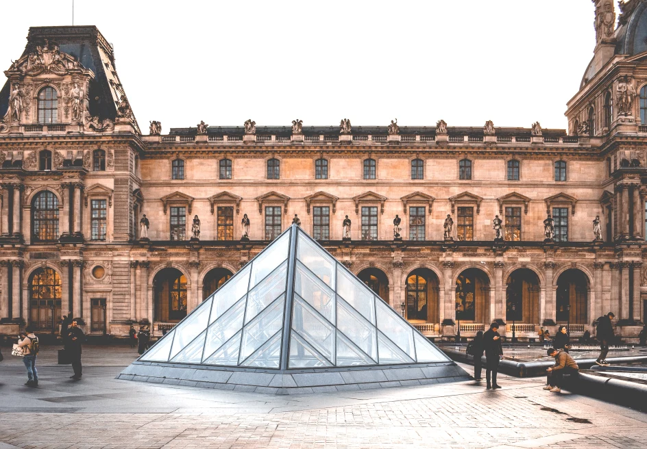 pink brown building louvre glass pyramid people standing outside