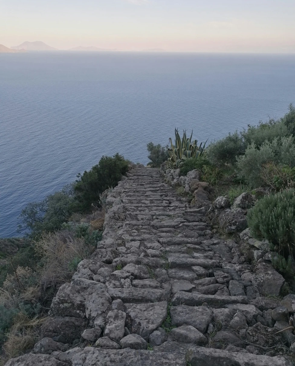 A stair case towards sea during daytime. 