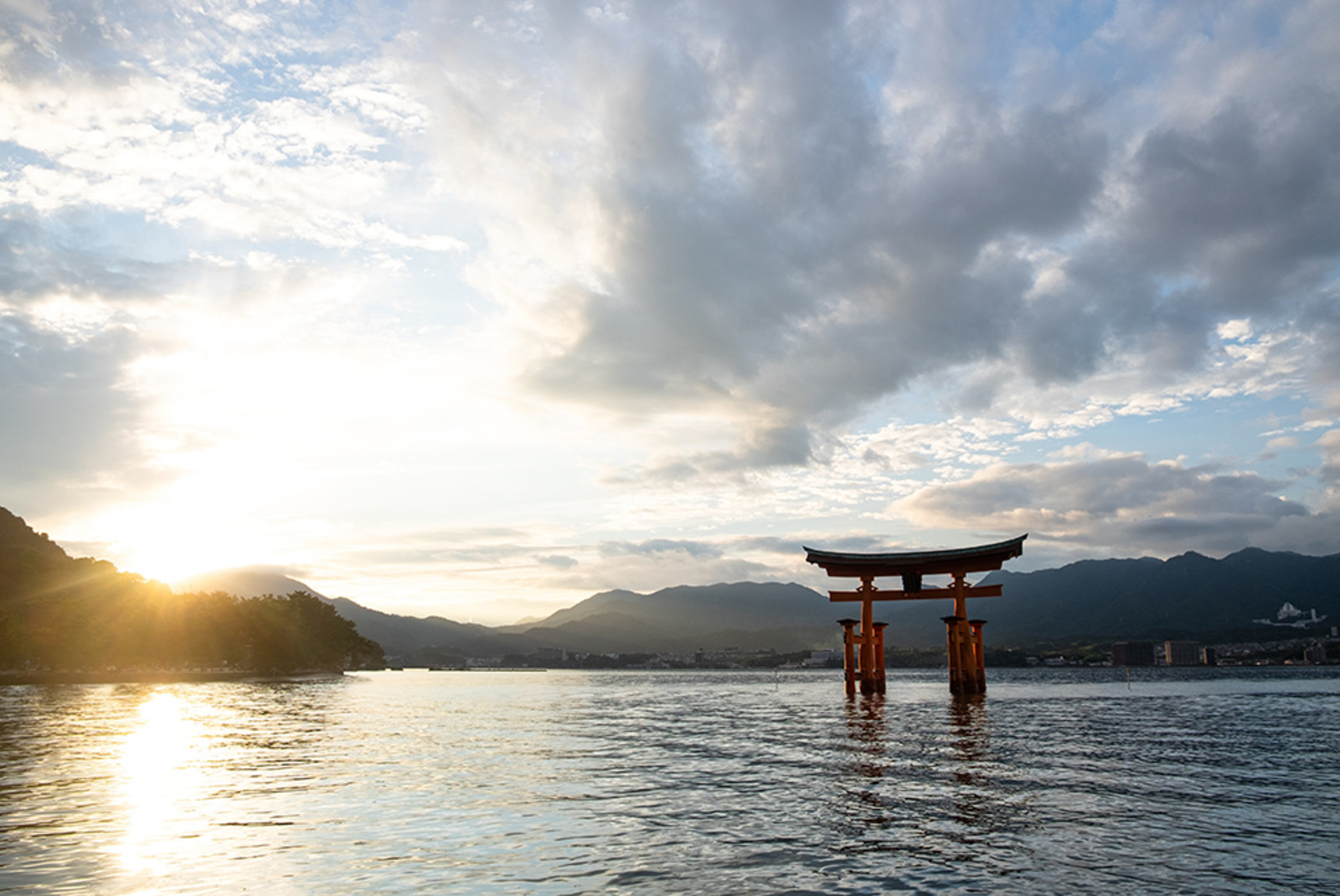 Japanese temple in lake at sunrise with mountains