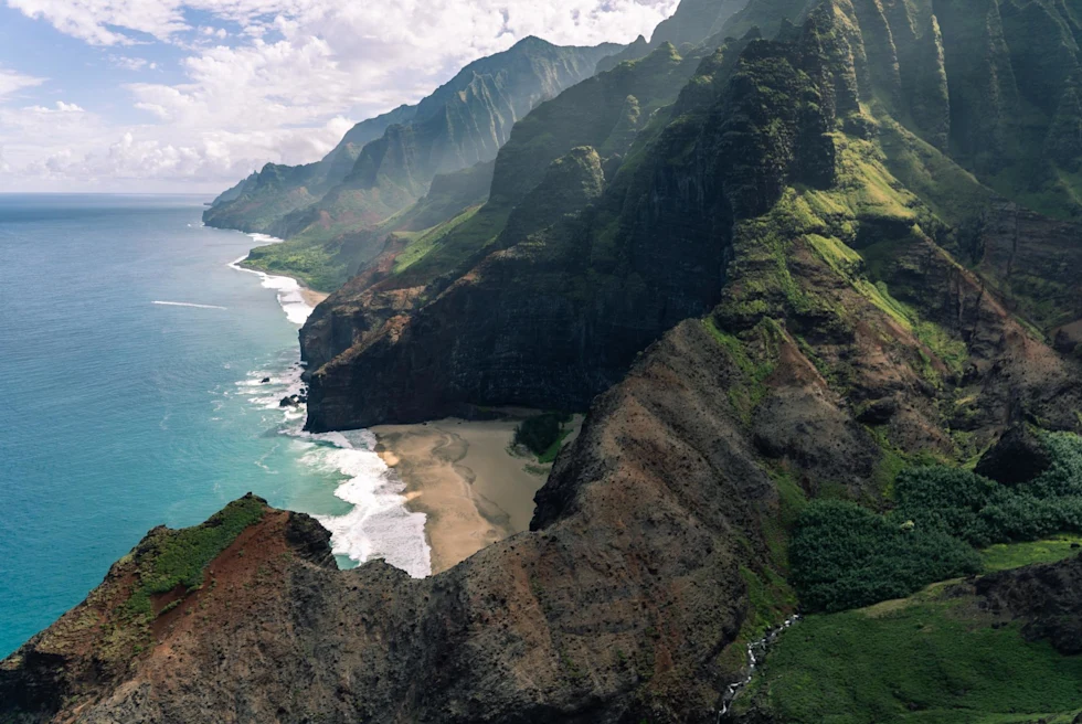 Ridges and mountains along the coast of Kauai on a sunny day.