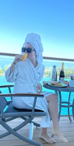 woman in a robe drinking a glass of orange juice
