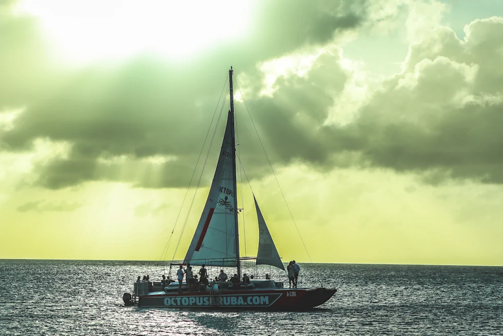 Octopus Catamaran in the ocean in Aruba with sun shining through clouds